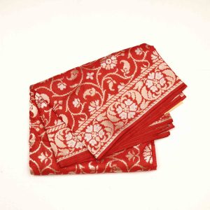 Cherry red Banaras pattu saree showcasing dense golden zari paisley patterns along border and pallu on lustrous silk fabric highlighting handwoven texture