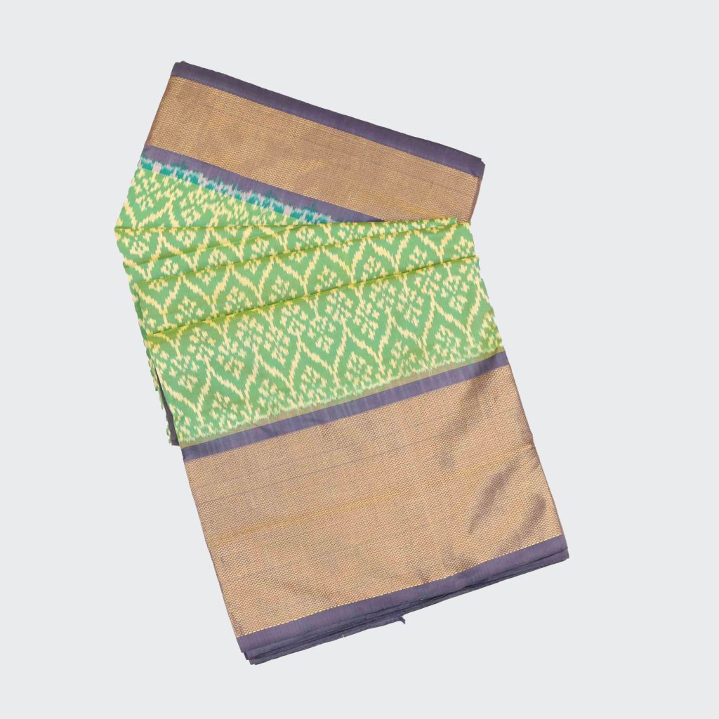 Gray and light green Pochampally pattu saree with precise ikat motifs on glossy silk fabric showcasing contrasting panels and detailed handwoven texture